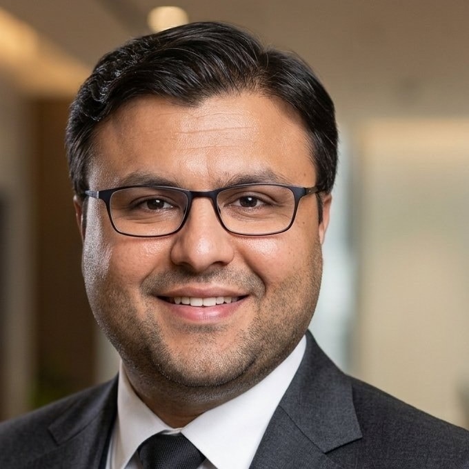 Square headshot of Shahfayaz Khan in three-piece suit smiling
